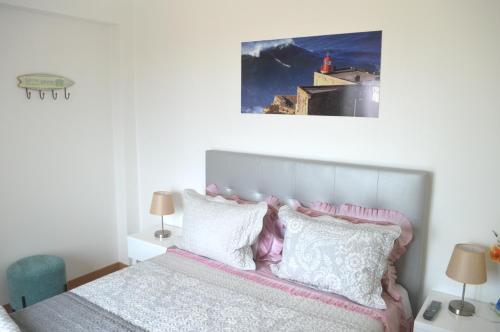 1 dormitorio con 1 cama con almohadas rosas y blancas en Holidays 71, en Nazaré