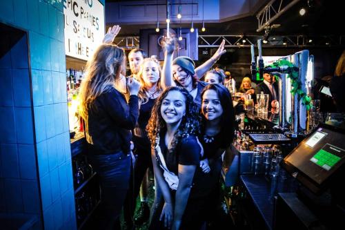 a group of people standing in a bar at St Christopher's Inn Shepherd's Bush in London