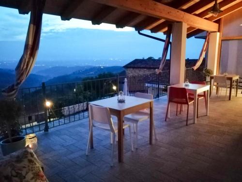 a patio with tables and chairs and a view at Villa Belvedere Langhe in Belvedere Langhe