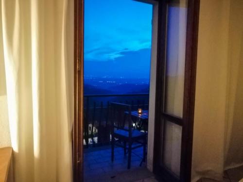 a room with a window with a view of a table at Villa Belvedere Langhe in Belvedere Langhe