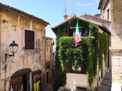 una bandiera italiana appesa a un edificio con edera di "Il Nido" a Sermoneta