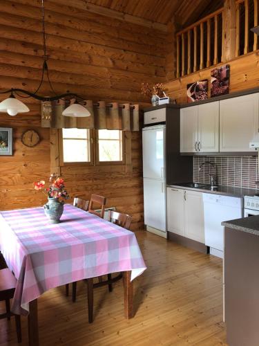 a kitchen with a table with a pink and white table cloth at Ollinmäki Vineyard in Anttola