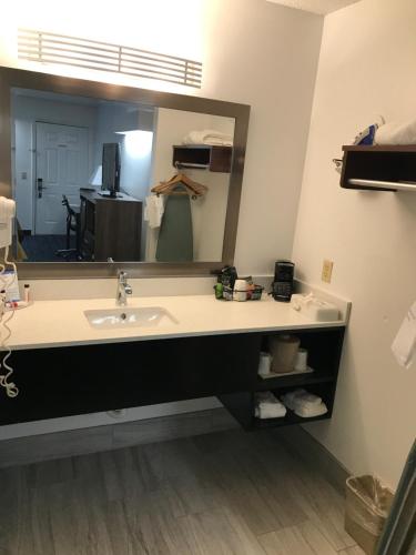a bathroom with a sink and a large mirror at Baymont by Wyndham Anderson Clemson in Anderson