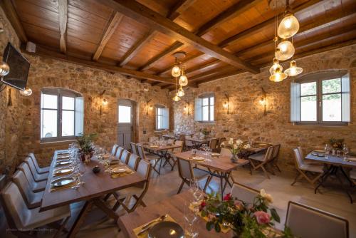 uma sala de jantar com mesas e cadeiras de madeira em IPPOLA BOUTIQUE HOTEL em Érimos