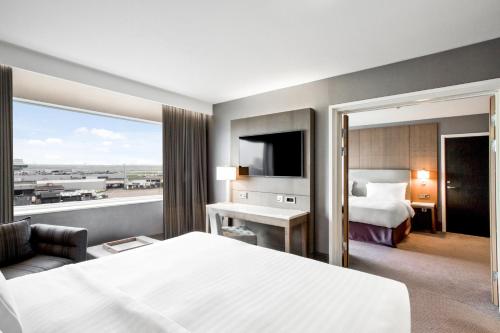 a hotel room with a bed and a desk at Radisson Blu Manchester Airport in Hale