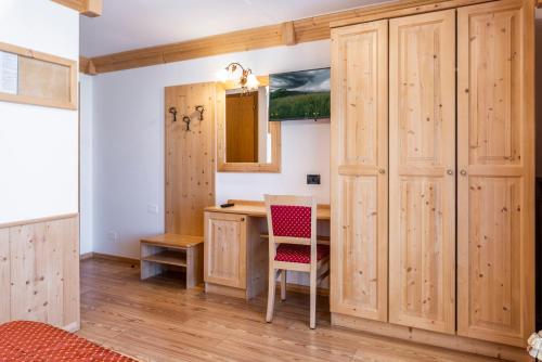 a kitchen with wooden cabinets and a desk with a chair at LM Rooms in Fondo