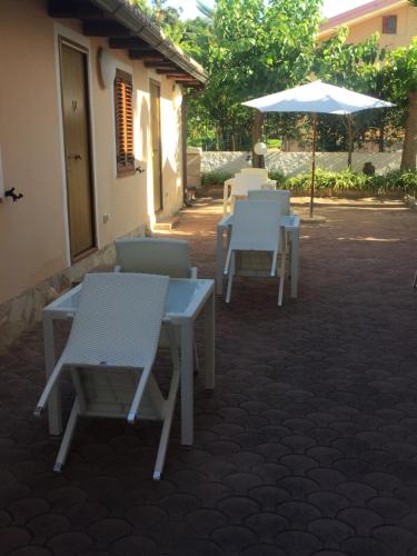a group of tables and chairs and an umbrella at Villa Grazia in Capo Vaticano