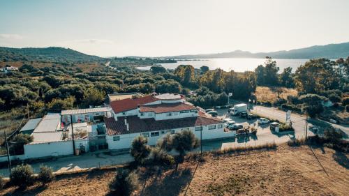 an aerial view of a building with a lake in the background at Hotel Il Timone in Cugnana