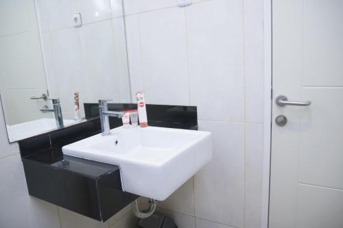 y baño con lavabo blanco y espejo. en Super OYO 1006 Azzahra Guest House Syariah, en Ambon