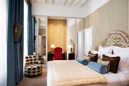 a bedroom with a large bed with blue pillows at Relais Christine in Paris
