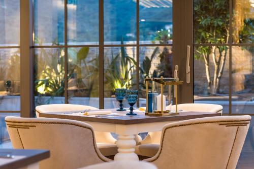 a table and chairs in a room with windows at Boutique Hotel & Spa Casa del Mare - Mediterraneo in Herceg-Novi