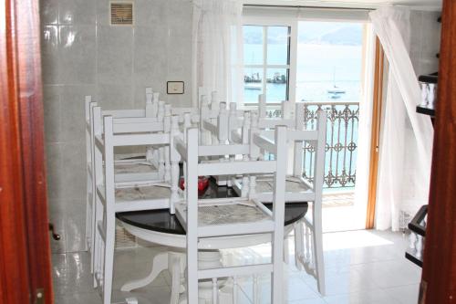un grupo de sillas blancas sentadas en una habitación en Apartmentos Vistamar Galicia Raxó, en Raxó