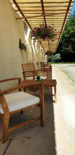 a group of wooden benches sitting under a roof at Cosy Er Lann Gîte Cèdre in Val Couesnon