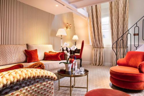 a living room with a couch and two chairs at Relais Christine in Paris