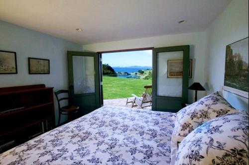 a bedroom with a bed and a view of a field at Waiwurrie Coastal Farm Lodge in Mahinepua