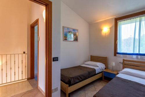 Habitación pequeña con 2 camas y ventana en Bungalow S3, en Isola Albarella