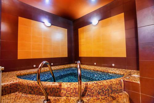 リヴィウにあるHotel Fortunaのタイル張りのジャクジーバスタブ付きのバスルーム