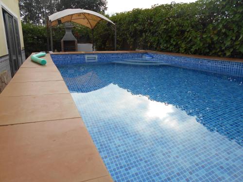 埃爾韋爾赫爾的住宿－Casa La Madriguera，蓝色瓷砖游泳池,带雨伞