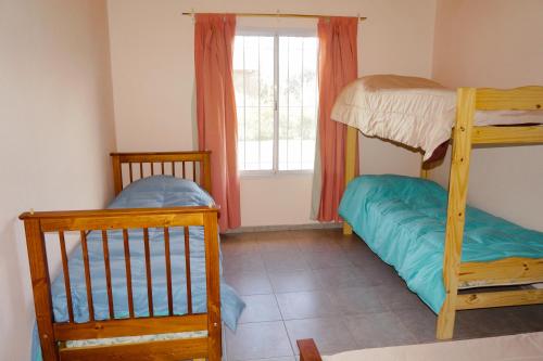 een slaapkamer met twee stapelbedden en een raam bij Complejo Los Olivos in San Rafael