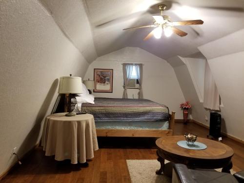 a bedroom with a bed with a ceiling fan and a table at Almond Cabin in Fredericksburg