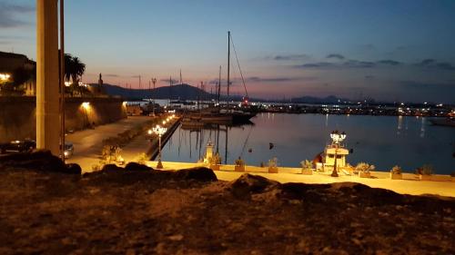 a marina at night with boats in the water at Musica Guest House in Alghero