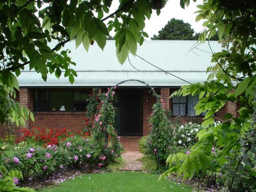 a brick house with a garden with flowers at Warkworth Country House in Warkworth