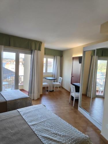 um quarto de hotel com duas camas e uma varanda em Hotel Nuevo Cachalote no Portonovo