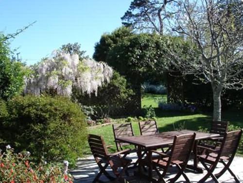 a wooden table and chairs in a garden at Warkworth Country House in Warkworth