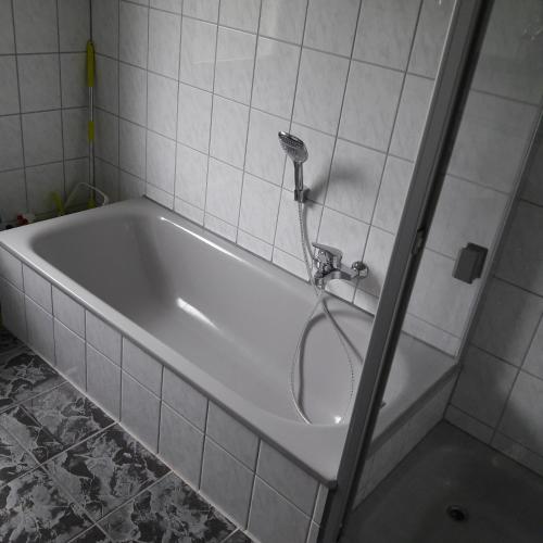 y baño con bañera blanca y ducha. en holydayhome FeWo Schwarz, en Eberstadt