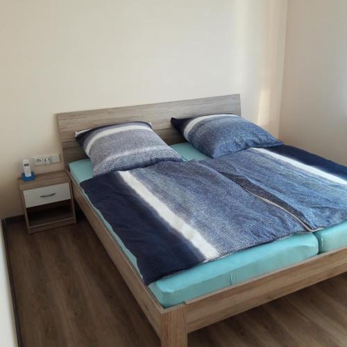 1 dormitorio con 1 cama con sábanas y almohadas azules en holydayhome FeWo Schwarz, en Eberstadt