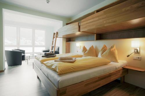 a bedroom with a large bed with a wooden headboard at Mühlbacherhof in Rennweg