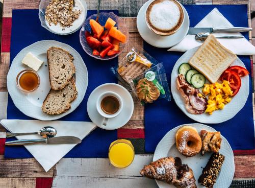 a table with plates of breakfast foods and a cup of coffee at Hotel Residence Mara in Lido di Jesolo