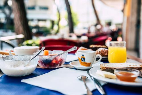 Hotel Residence Mara في ليدو دي يسولو: طاولة زرقاء عليها طعام ومشروبات للإفطار