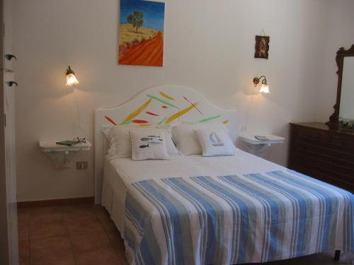 トッレ・スーダにあるIl Gabbianoのベッドルーム1室(青と白のストライプシーツが施されたベッド1台付)
