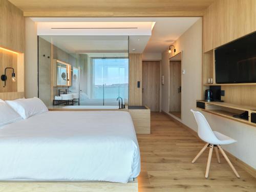 a hotel room with two beds and a television at Noa Boutique Hotel in Santa Cruz de Oleiros