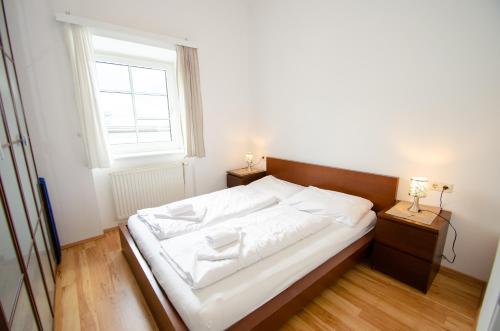 a bedroom with a large white bed with a window at Apartment CityXpress TOP 7 in Zell am See