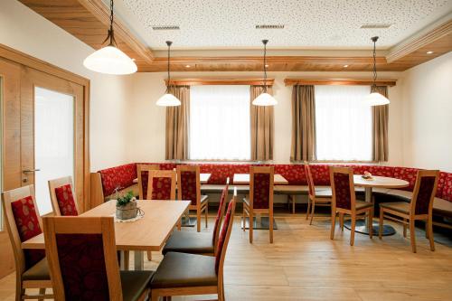 a dining room with tables and chairs and windows at Mühlbacherhof in Rennweg