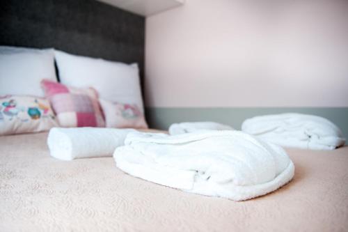 Duas toalhas empilhadas em cima de uma cama em Amelia Suite em Gdansk
