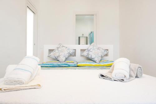 a white room with two pillows and towels at Villa Acquamarina sul mare in San Vito lo Capo