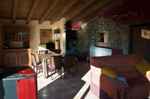 a living room with a couch and a table with chairs at Can Poca Roba in Sant Pere de Torelló