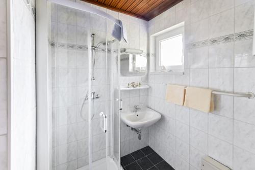 a white bathroom with a shower and a sink at Bungalows Angelika am Klopeinersee Turnersee in Sankt Kanzian
