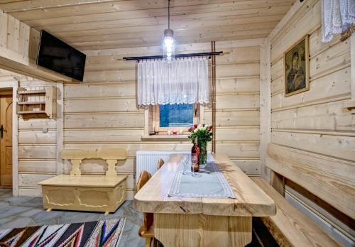 a wooden room with a table and a window at Jędroskowe Chatki in Witów
