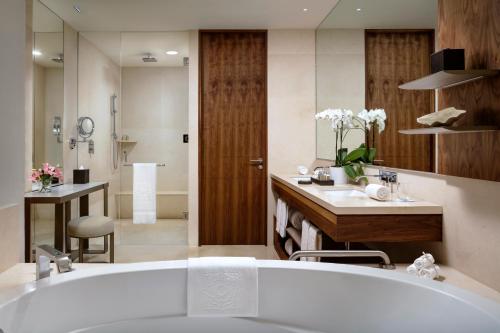 a bathroom with a bath tub and a sink at Grand Velas Los Cabos Luxury All Inclusive in Cabo San Lucas