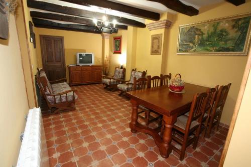 uma sala de jantar com uma mesa e cadeiras e uma televisão em Casa Rural Calderón de Medina l, ll y lll em Siete Iglesias de Trabancos