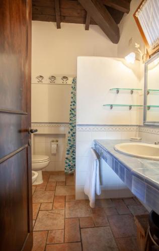 a bathroom with a sink and a toilet at Villa Kalè - Klodge in Olbia