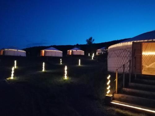 a group of tents with lights in the dark at Jurta Hotel Balatongyörök in Balatongyörök