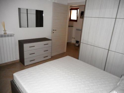 1 dormitorio con cama blanca y vestidor en Giulia, en Gaeta
