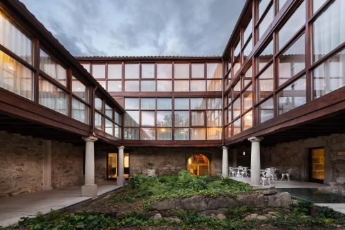 an exterior view of a building with large windows at Áurea Palacio de Sober by Eurostars Hotel Company in Sober
