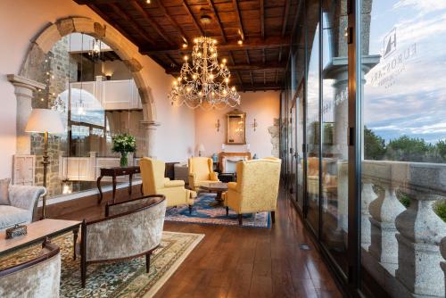 a living room with a chandelier and yellow chairs at Áurea Palacio de Sober by Eurostars Hotel Company in Sober