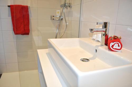 a white sink in a bathroom with a shower at Best Western Hotel Rebstock in Rorschacherberg